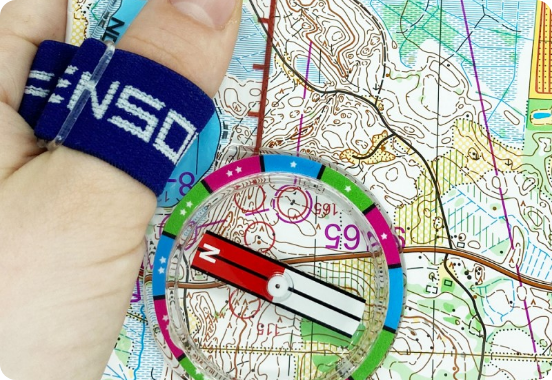 Carta di orienteering e bussola tenute in mano